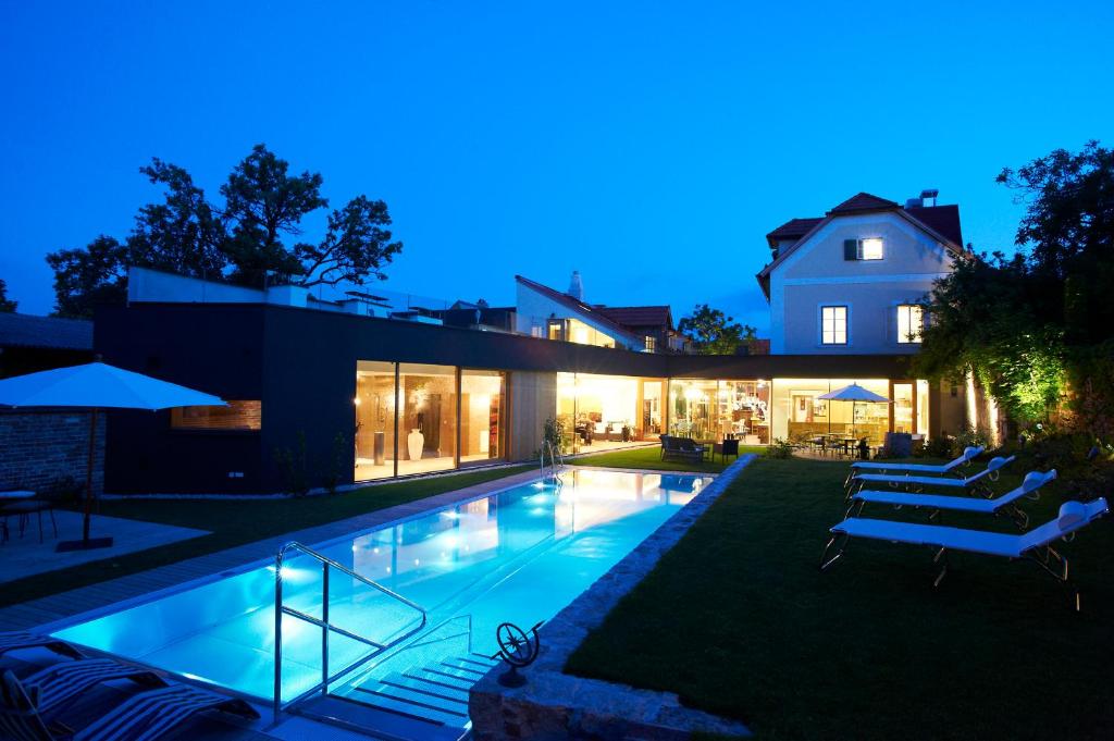 uma casa com piscina à noite em Hotel Landhaus Moserhof em Gumpoldskirchen