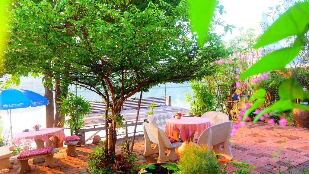 d'une terrasse avec des tables, des chaises et un arbre. dans l'établissement Loy Manee House, à Phra Nakhon Si Ayutthaya