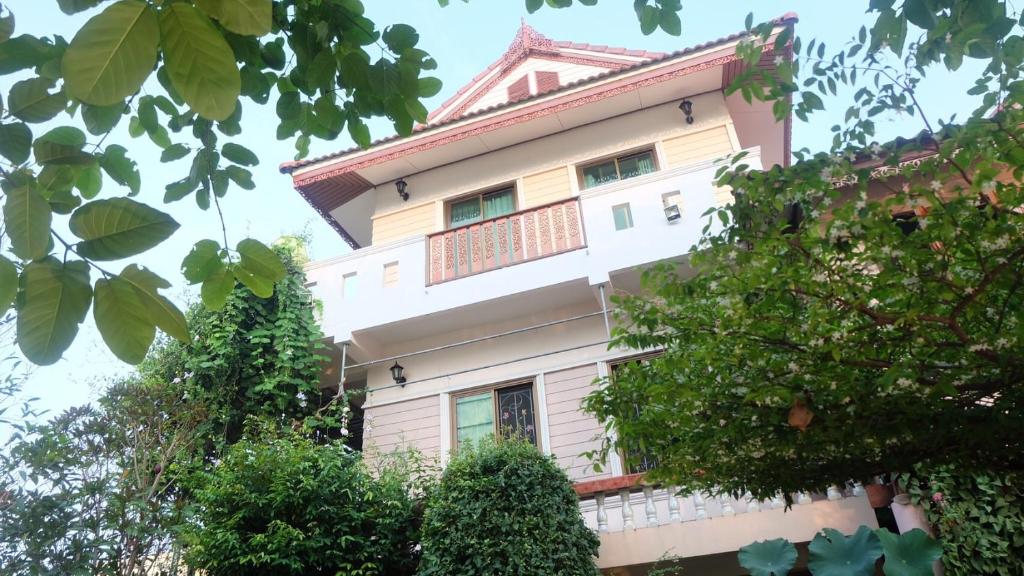 a tall white building with a red roof at Loy Manee House in Phra Nakhon Si Ayutthaya