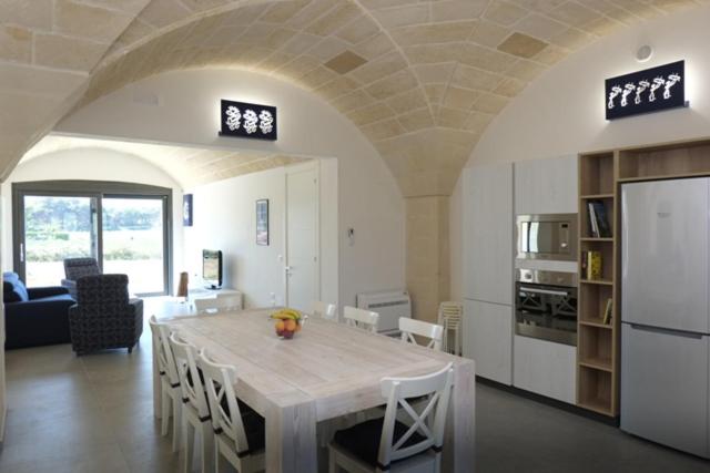 オートラントにあるVilla Baia dei Turchiのキッチン、ダイニングルーム(白いテーブル、椅子付)