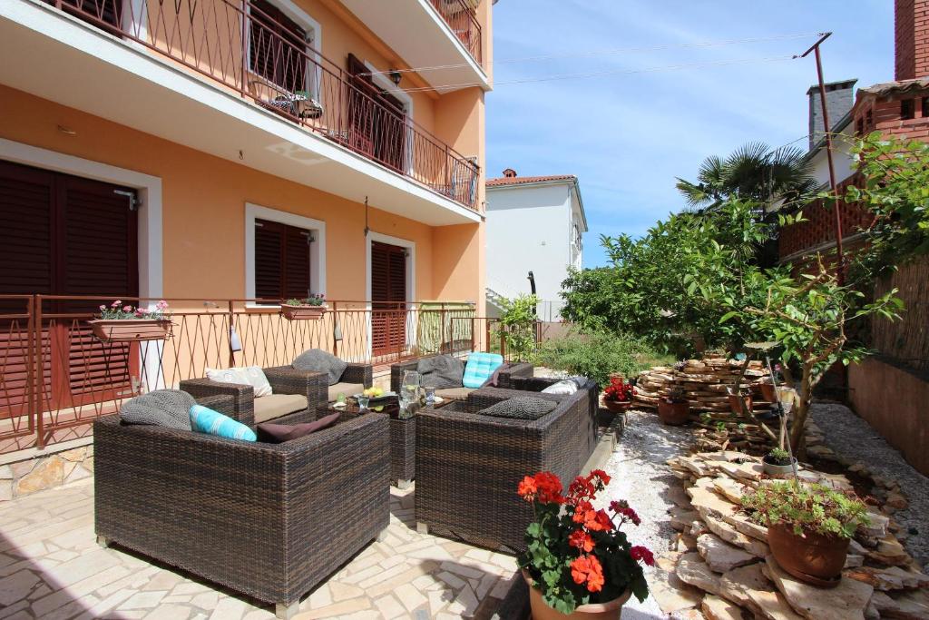 un patio con due divani in vimini e fiori accanto a un edificio di Apartments Villa Nikola a Rovigno (Rovinj)