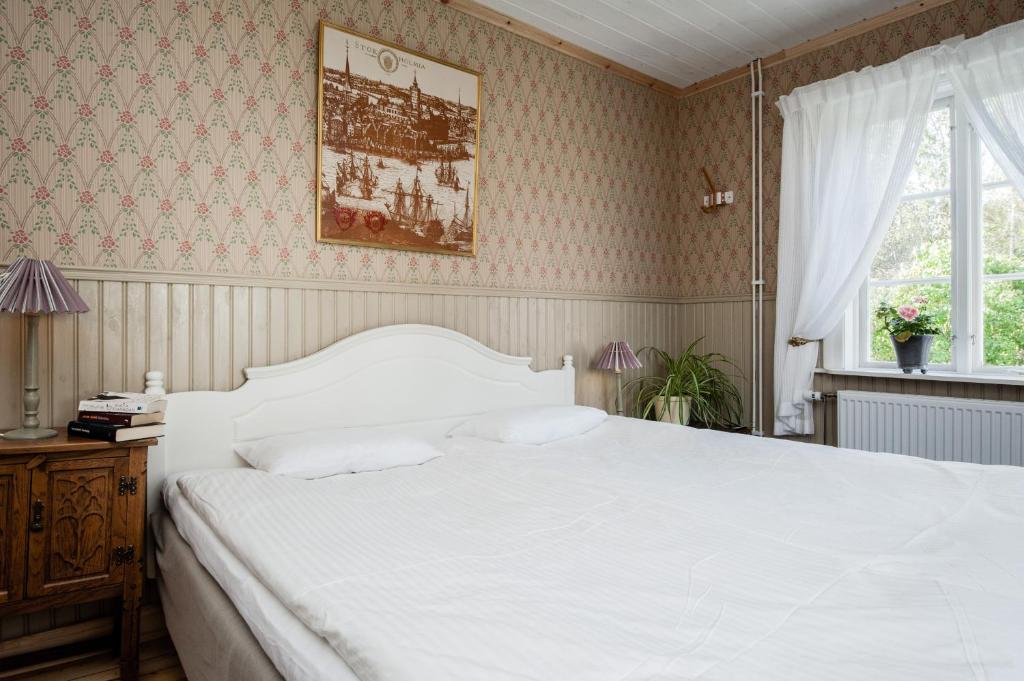Un dormitorio con una gran cama blanca y una ventana en Enångers Bed and Breakfast, en Enånger