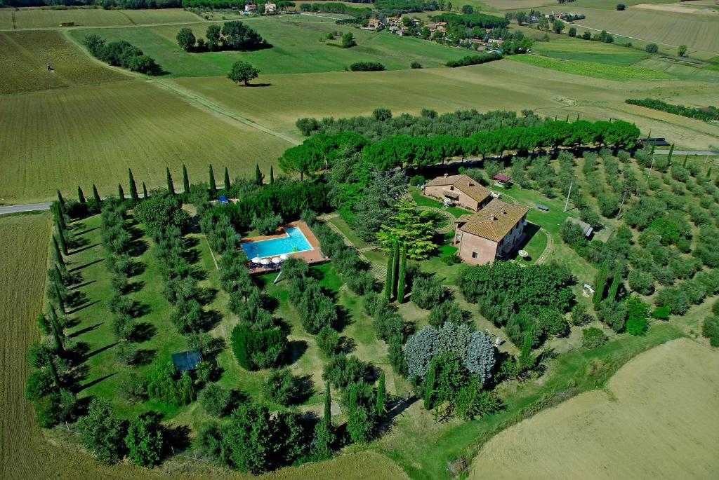an aerial view of a house with trees and a pool at Poggio del Sole in Castiglione del Lago
