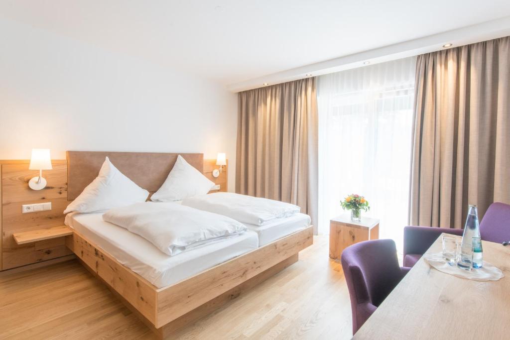 ヴァルトキルヒにあるHotel & Gasthaus Löwenのベッド、テーブル、椅子が備わるホテルルームです。