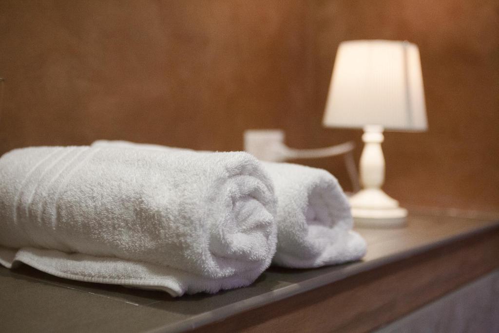two towels are stacked on a table with a lamp at B&B Regina ELENA in Campobasso