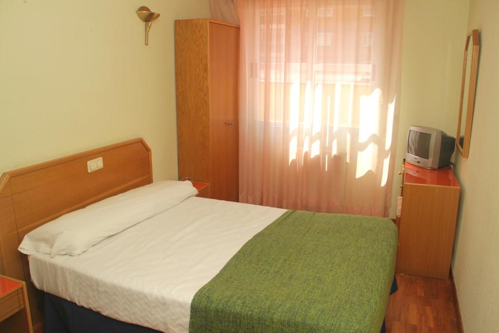 a bedroom with a bed and a desk at Hostal Arlanzón in Burgos