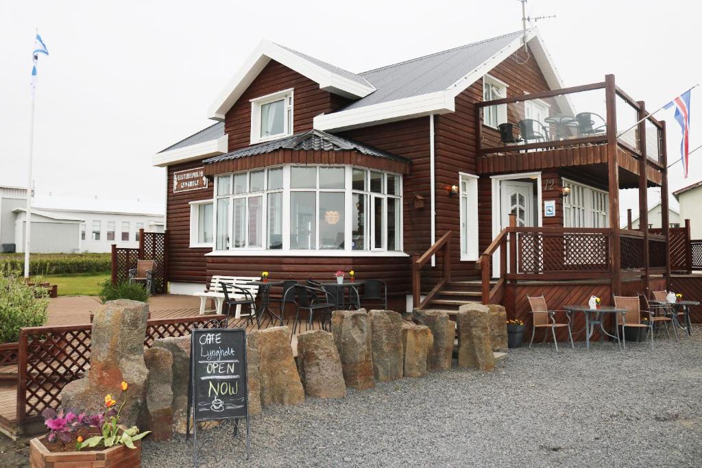 een houten huis met een bord ervoor bij Guesthouse Lyngholt in Þórshöfn