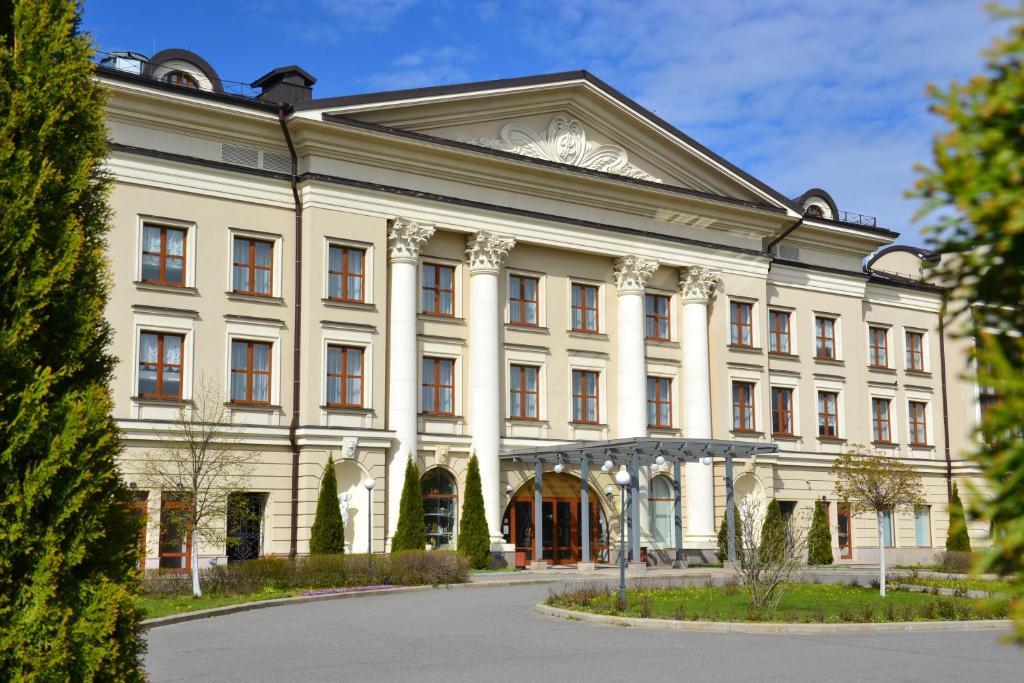 a large building with a clock on the front of it at Volzhskaya Riviera Hotel in Uglich
