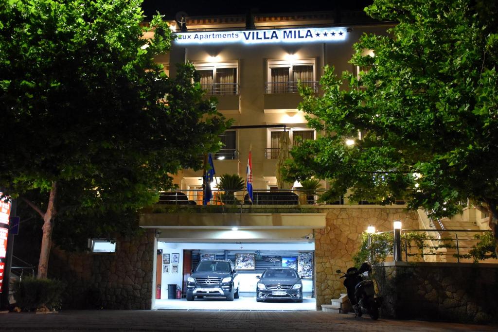 un edificio con coches estacionados frente a él en Villa Mila, en Tučepi