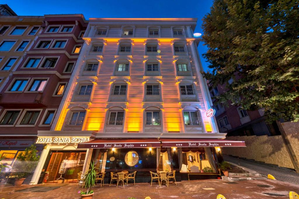 Santa Sophia Hotel - İstanbul في إسطنبول: مبنى امامه طاولات وكراسي