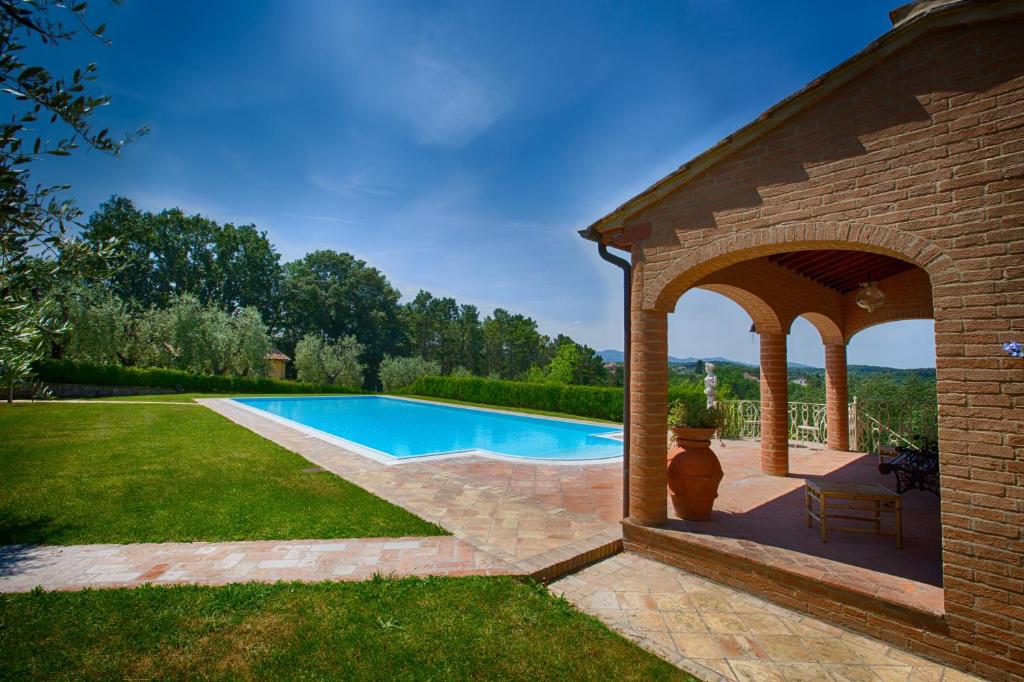 a swimming pool in a yard with a pavilion at Podere Sant'Antonio in Fauglia