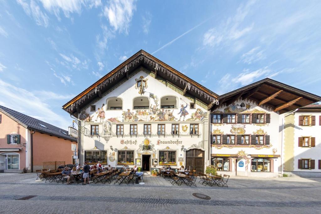 un gran edificio con gente sentada fuera de él en Hotel & Gasthof Fraundorfer, en Garmisch-Partenkirchen