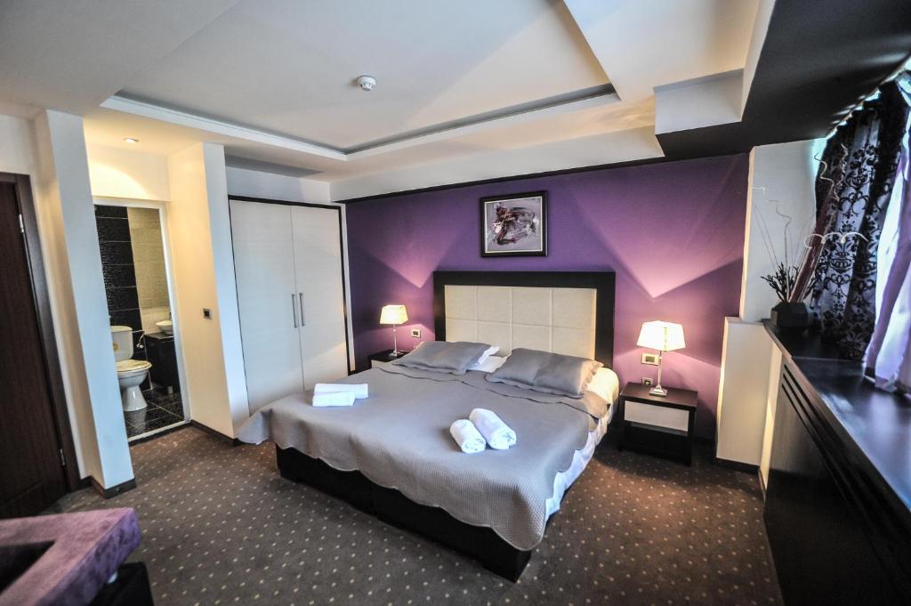 a bedroom with a large bed with purple walls at B&amp;B Rose in Vranje