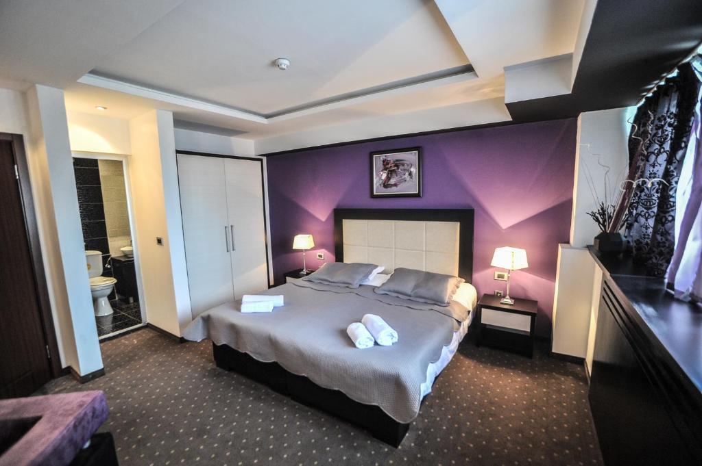 a bedroom with a large bed with purple walls at B&B Rose in Vranje