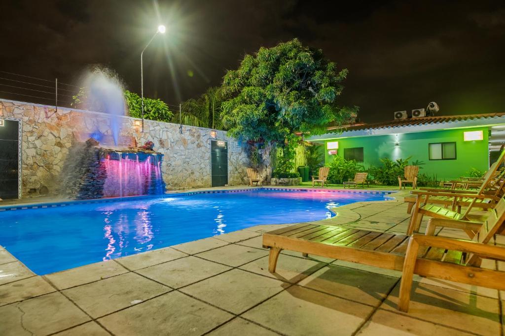 una piscina por la noche con una fuente en Hotel Los Chilamates en Granada