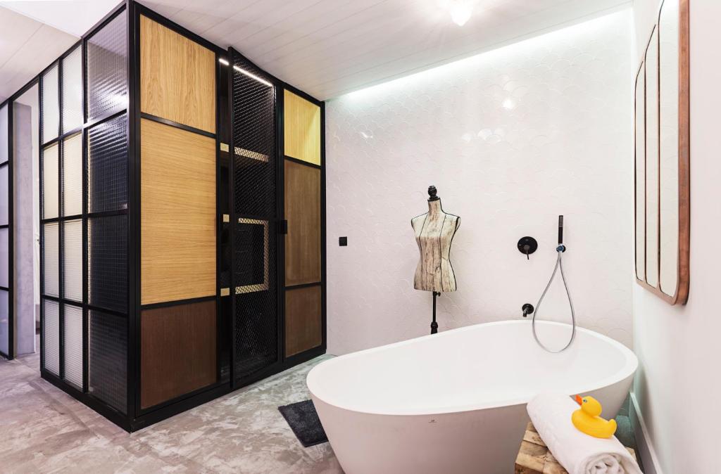 a bathroom with a white tub and a dressing room at One Shot Tabakalera House in Donostia-San Sebastián