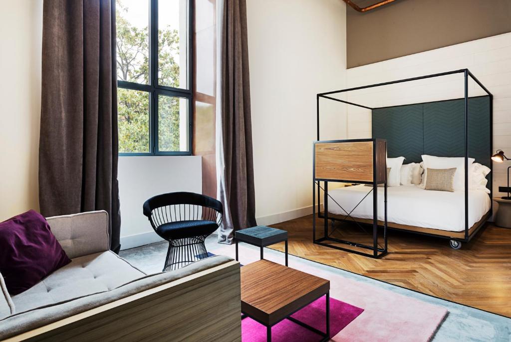 a living room with a couch and a bed at One Shot Tabakalera House in Donostia-San Sebastián