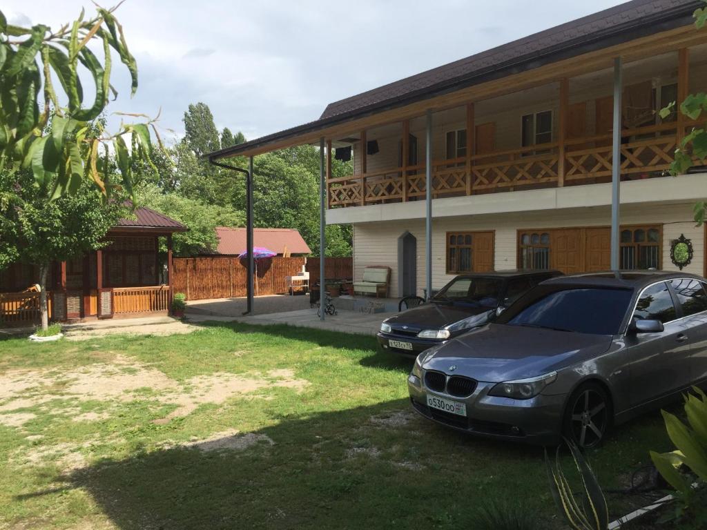 dos autos estacionados frente a una casa en Guest House Chanba, en Gudauta