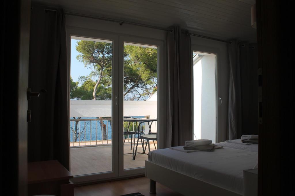 a bedroom with a bed and a view of a patio at Covahouse in Jelsa