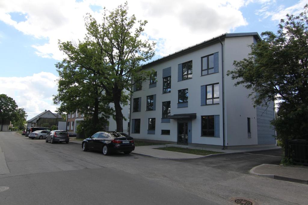 un edificio bianco con macchine parcheggiate di fronte di Raua 15 Apartment a Tartu