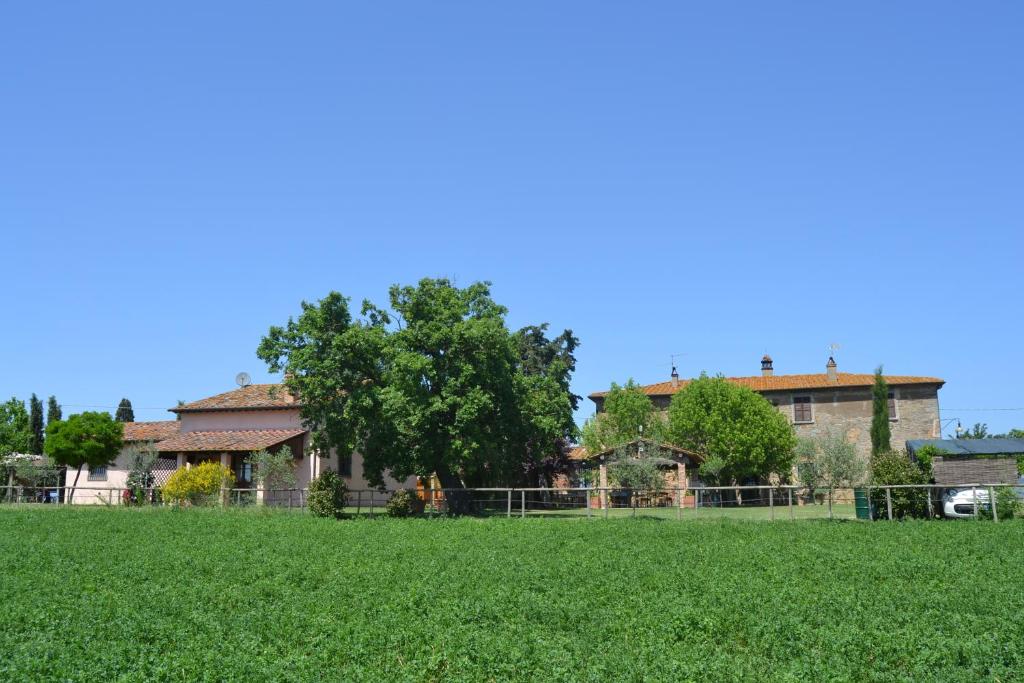 una casa con una valla y un campo de hierba en Cortona Holiday Home, en Cortona