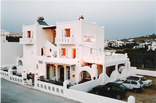 a white house with two cars parked in front of it at Barbaras in Naousa