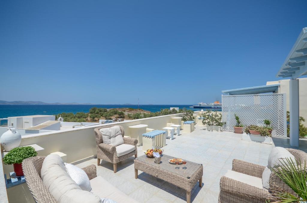 eine Terrasse mit Stühlen und Tischen auf dem Balkon in der Unterkunft Kymata Hotel in Naxos Chora