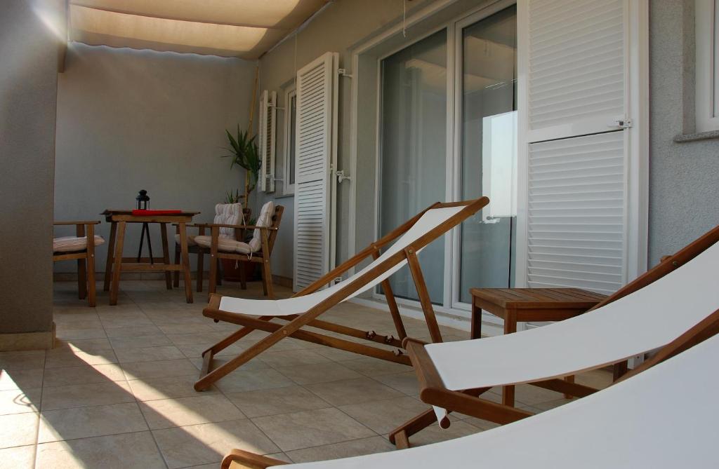 Banjol的住宿－Apartment Spanjol，一个带摇椅和一张桌子的阳台。