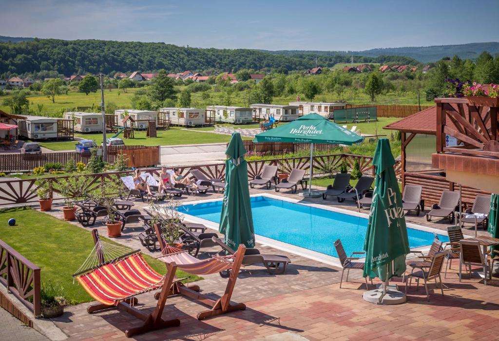 a resort with a pool and chairs and umbrellas at Nemeth Camping Spa & Pool Access in Sovata