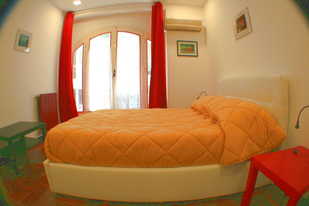 パレルモにあるAppartamento Politeamaの窓付きの部屋のオレンジ色のベッド1台