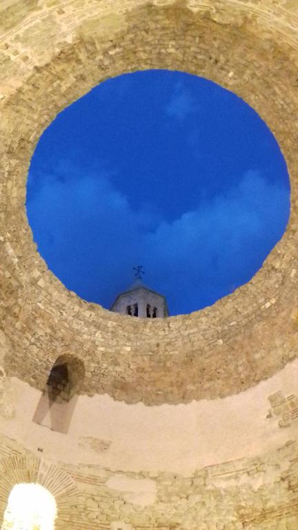 a view of the sky through a hole in a wall at Apartments Crvena Orhideja in Split