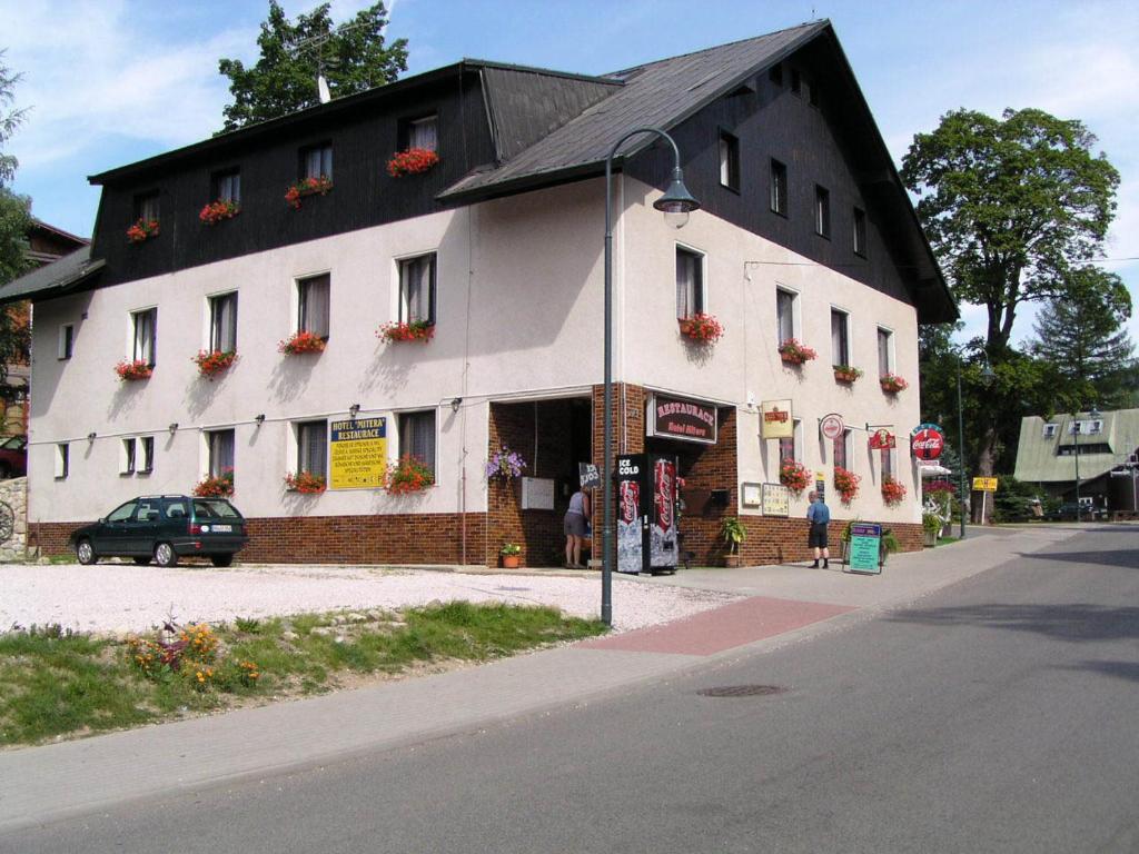 duży biały budynek z czarnym dachem w obiekcie Hotel Anna w mieście Harrachov