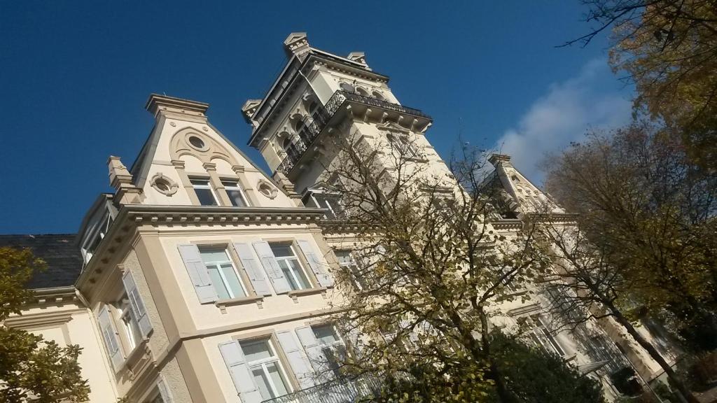 a tall building with a tower on top of it at Ekatarina Apartments in Baden-Baden