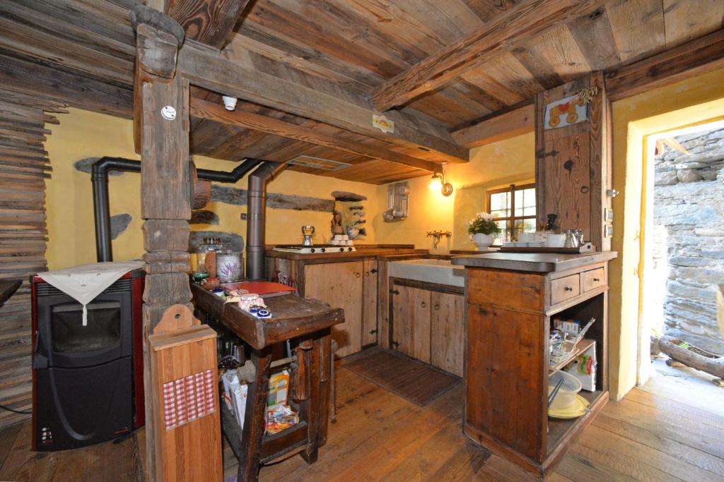 a large kitchen with wooden floors and wooden ceilings at B&B Il Torchio in Saint Vincent