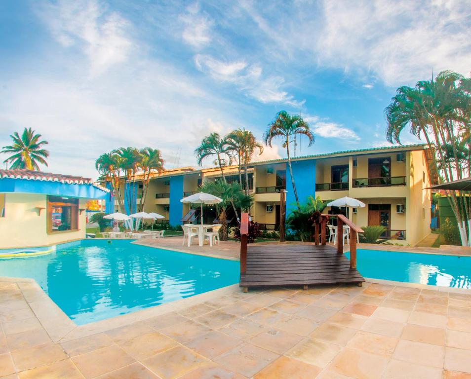 un complejo con piscina y palmeras en Sueds Premium, en Porto Seguro