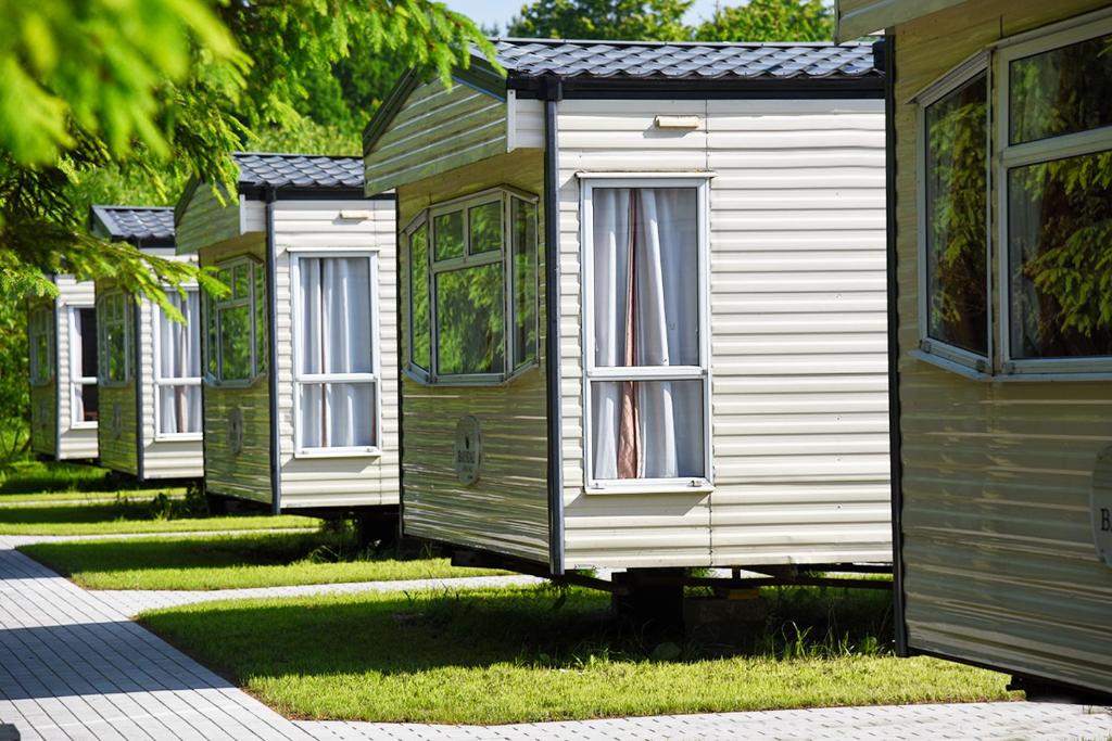 a row of wooden homes in a row at Holiday Lodge in Pogorzelica