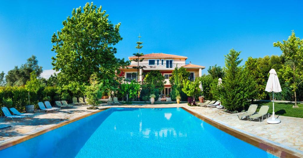 a swimming pool in front of a house at Lefkas Blue Residence in Lefkada
