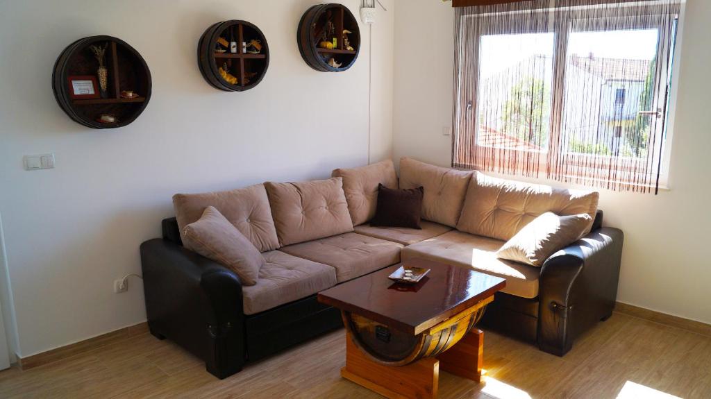 sala de estar con sofá marrón y mesa en Take A Break Apartments, en Brodarica