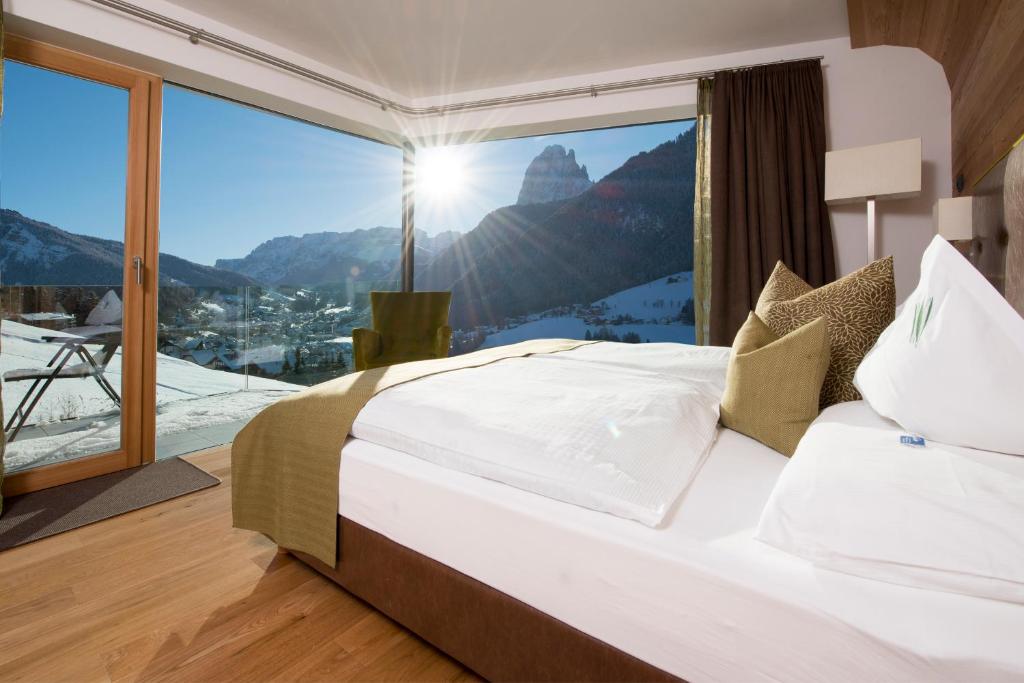 a bedroom with a bed with a mountain view at Hotel Grien in Ortisei