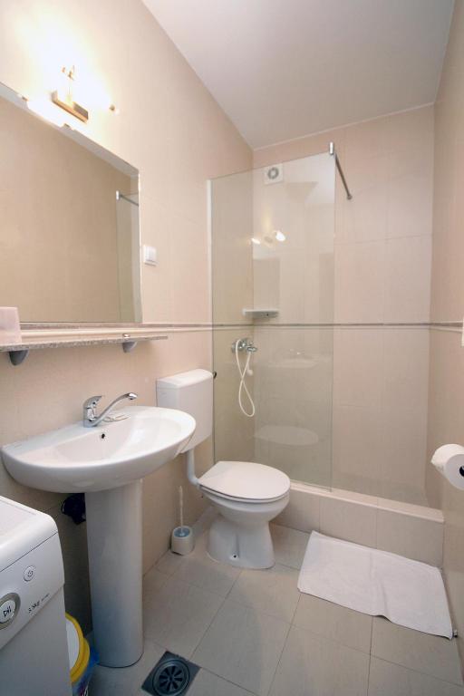 a bathroom with a sink and a toilet and a shower at Apartmani More in Sveti Stefan