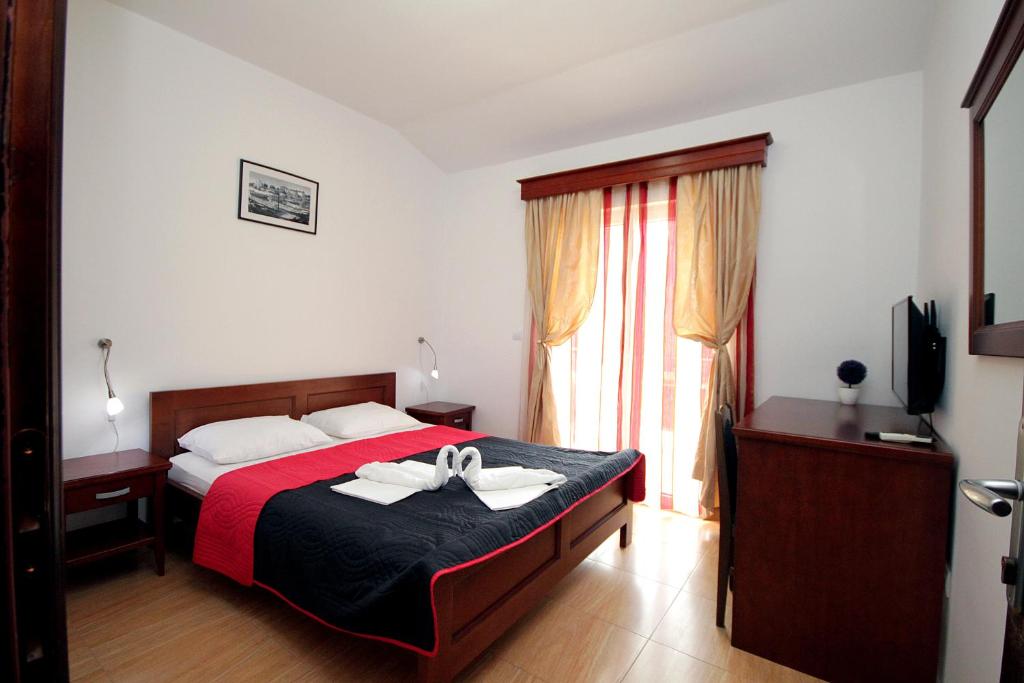 a bedroom with a bed with two towels on it at Apartmani More in Sveti Stefan