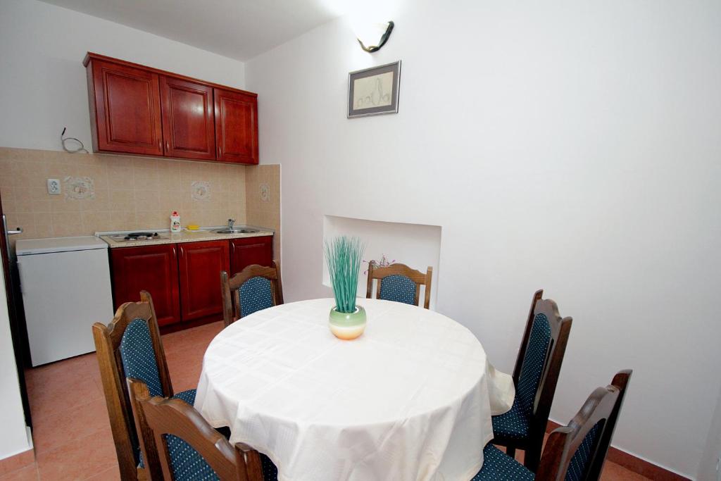a dining room with a table and a kitchen at Apartmani More in Sveti Stefan