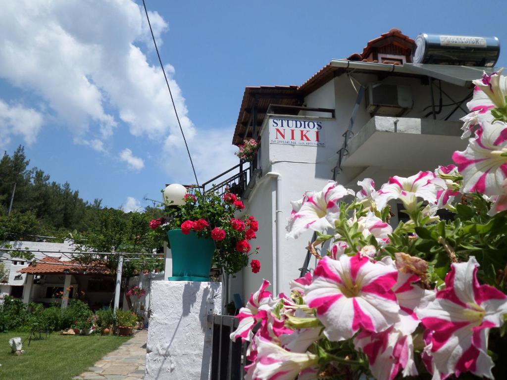 un edificio con dei fiori sul lato di Studios Niki a Kinira