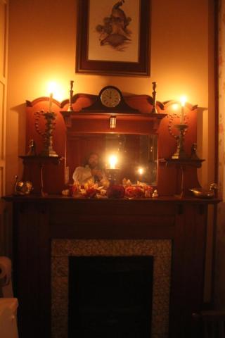 einen Kamin mit Kerzen und eine Uhr darüber in der Unterkunft Riverview Mansion Hotel in Golconda