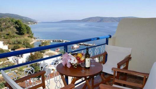 balcón con mesa y vistas al océano en Agnanti Hotel, en Kalamakia