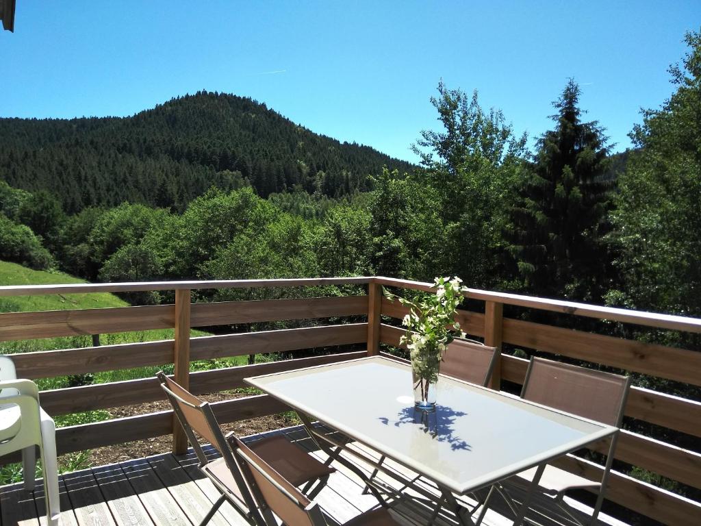 a table and chairs on a deck with a mountain at Gîte du Poirier in Le Tholy