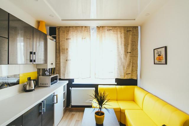 uma sala de estar com um sofá amarelo numa cozinha em VIP apartmen em Sumy