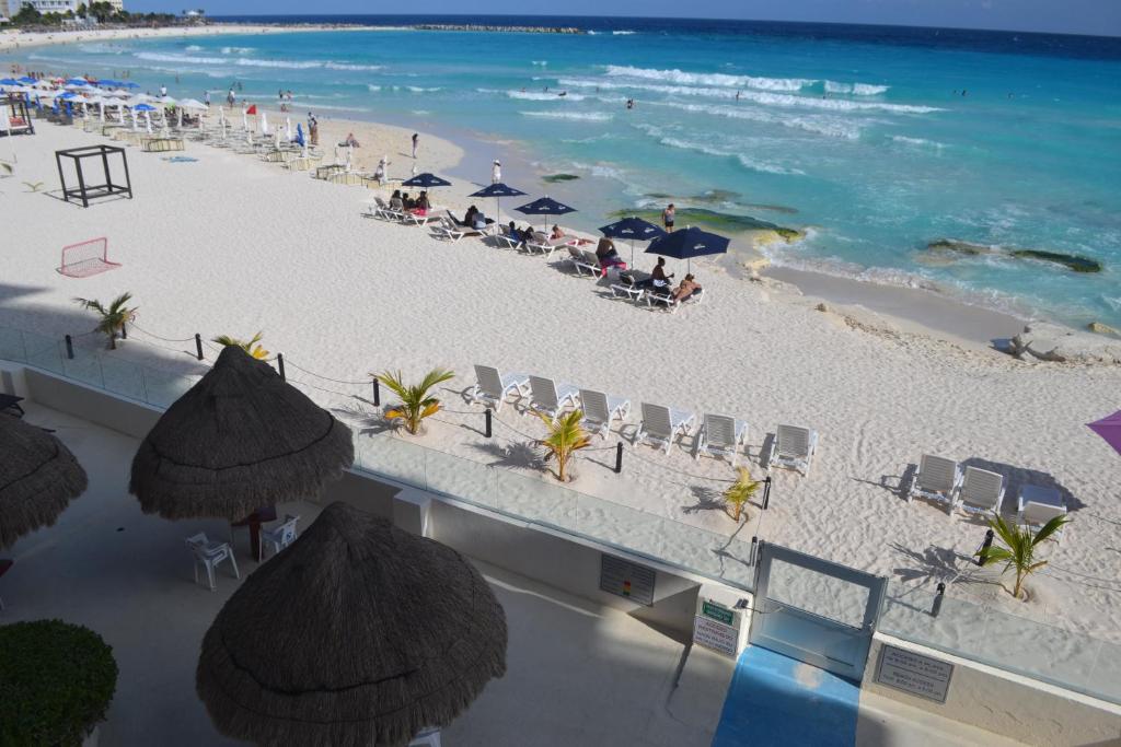 una vista aérea de una playa con sillas y sombrillas en Salvia Condominio, en Cancún