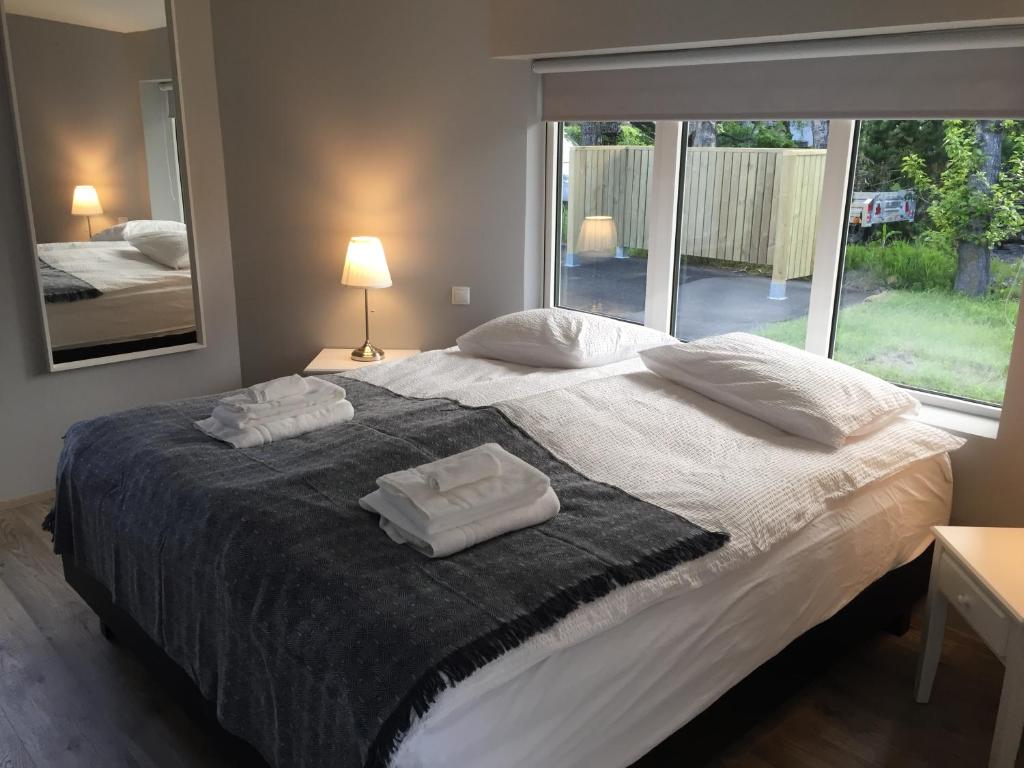 a bedroom with a large bed with two towels on it at Reykjadalur Guesthouse in Hveragerði