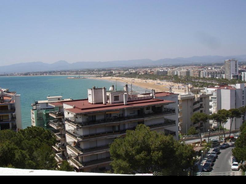 a large building next to a beach and the ocean at Apartamento JMAP in Salou